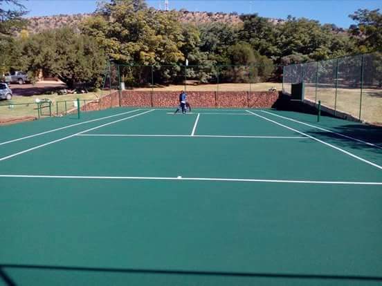 Tennis court after resurfacing, painted in all green.